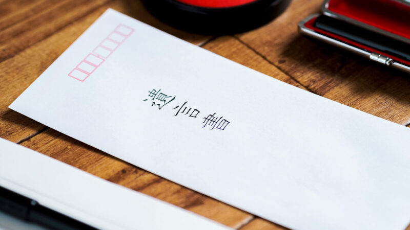 白い封筒に「遺言書」と印字され、印鑑と朱肉が並ぶ机の上の写真